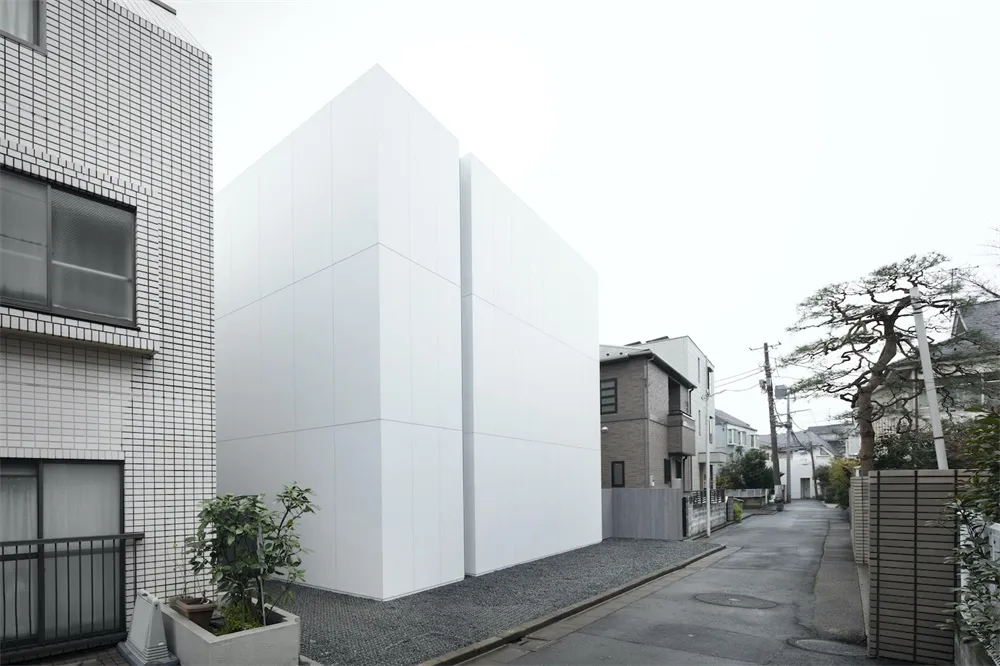 A minimalist residential exterior with smooth concrete walls.