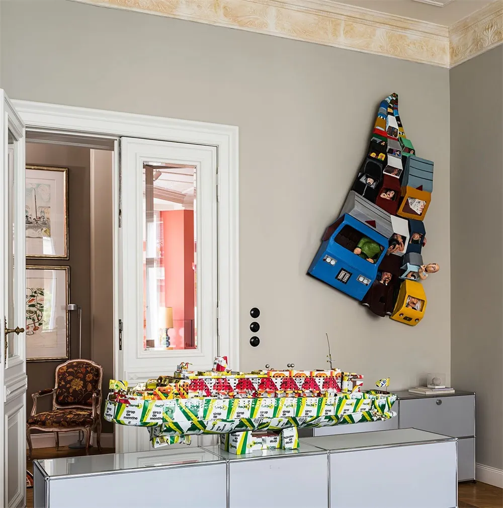 A modern, abstract sculpture displayed in a contemporary interior setting.