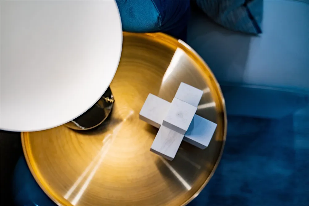 Modern table with metallic base and marble top, featuring geometric shapes and contemporary design elements.