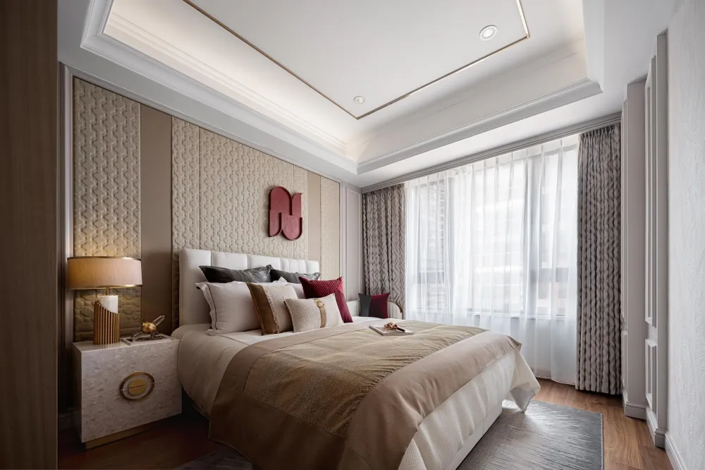 A modern bedroom featuring neutral-toned fabrics and textured wall paneling.
