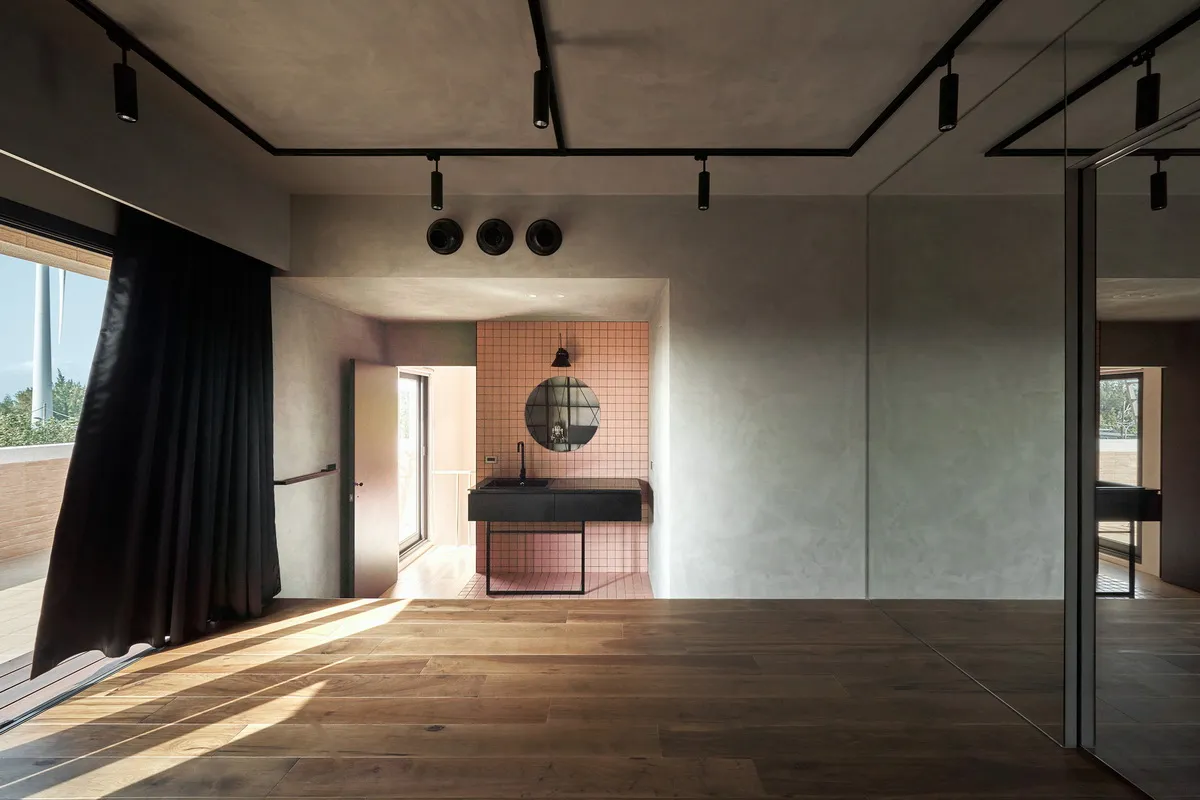 An interior view of a minimalist private residence featuring concrete and wooden materials.