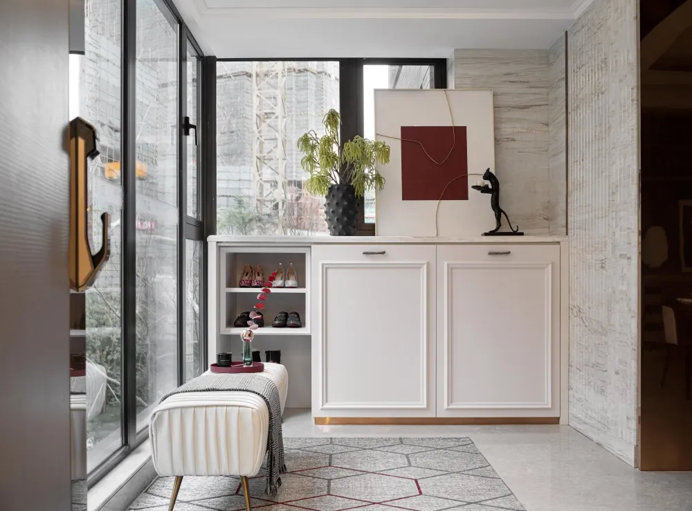 Entrance lounge area with marble floor, wooden seating, and glass elements