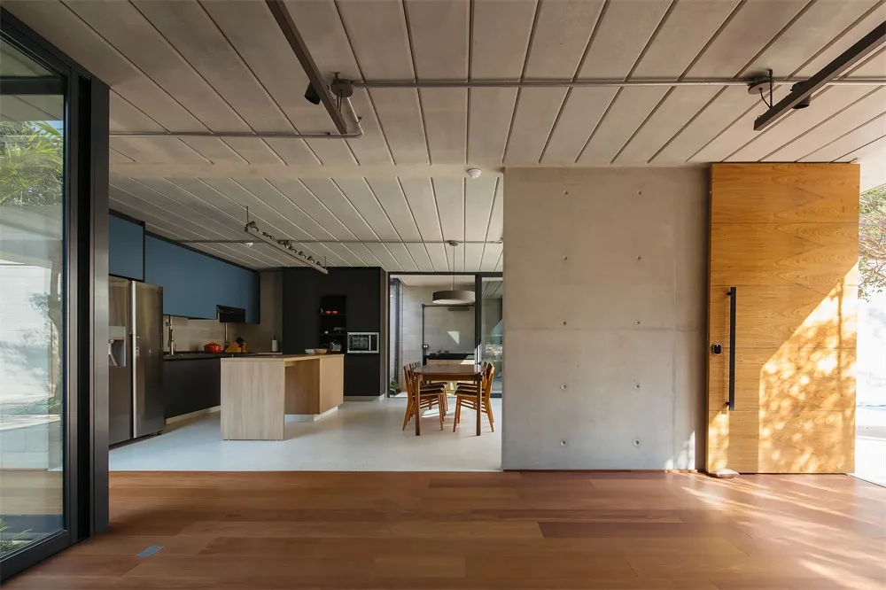 Modern residential kitchen and dining area with concrete and wooden elements