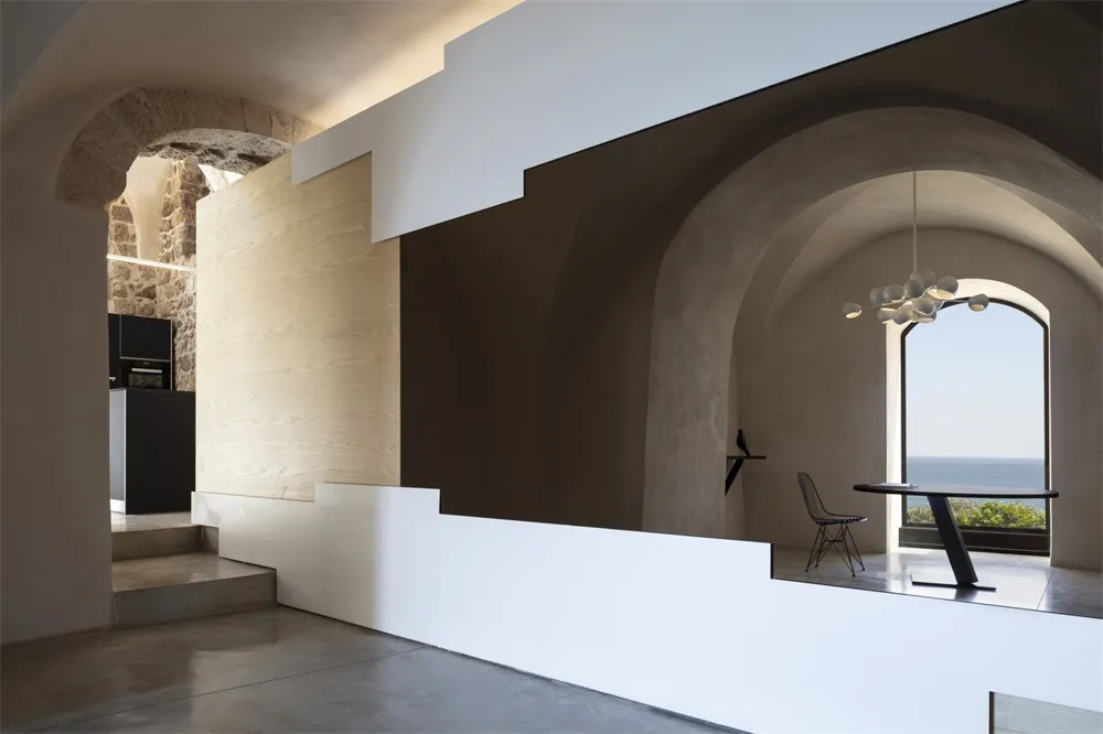 A modern residential interior featuring a monochrome color scheme and concrete finishes.