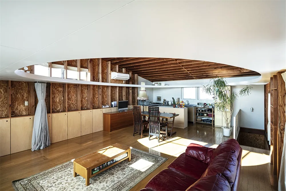 Industrial-style living room with wooden-paneled walls, leather sofa, and wooden coffee table.