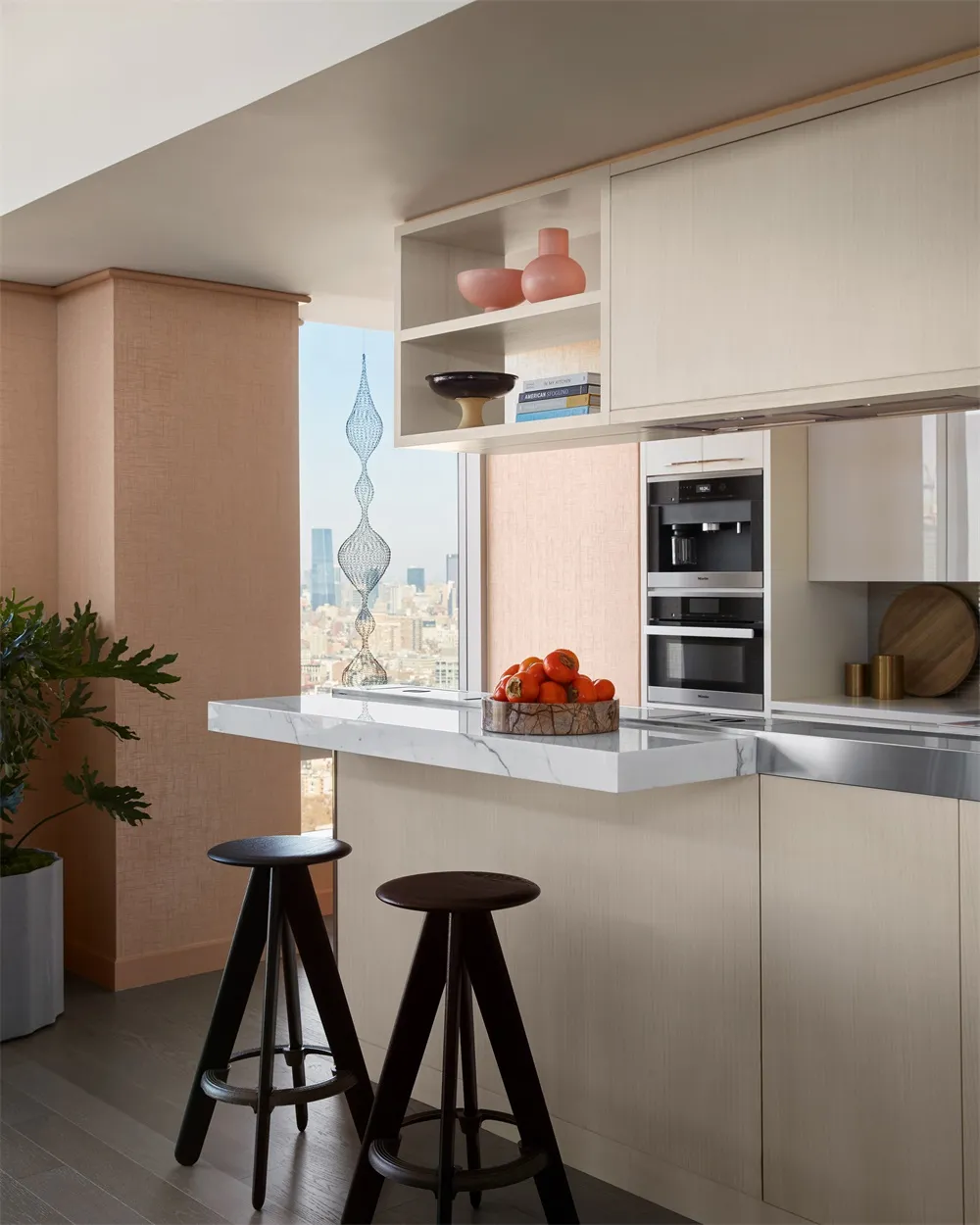 Modern minimalist kitchen featuring a marble countertop and stool seating with a cityscape view.