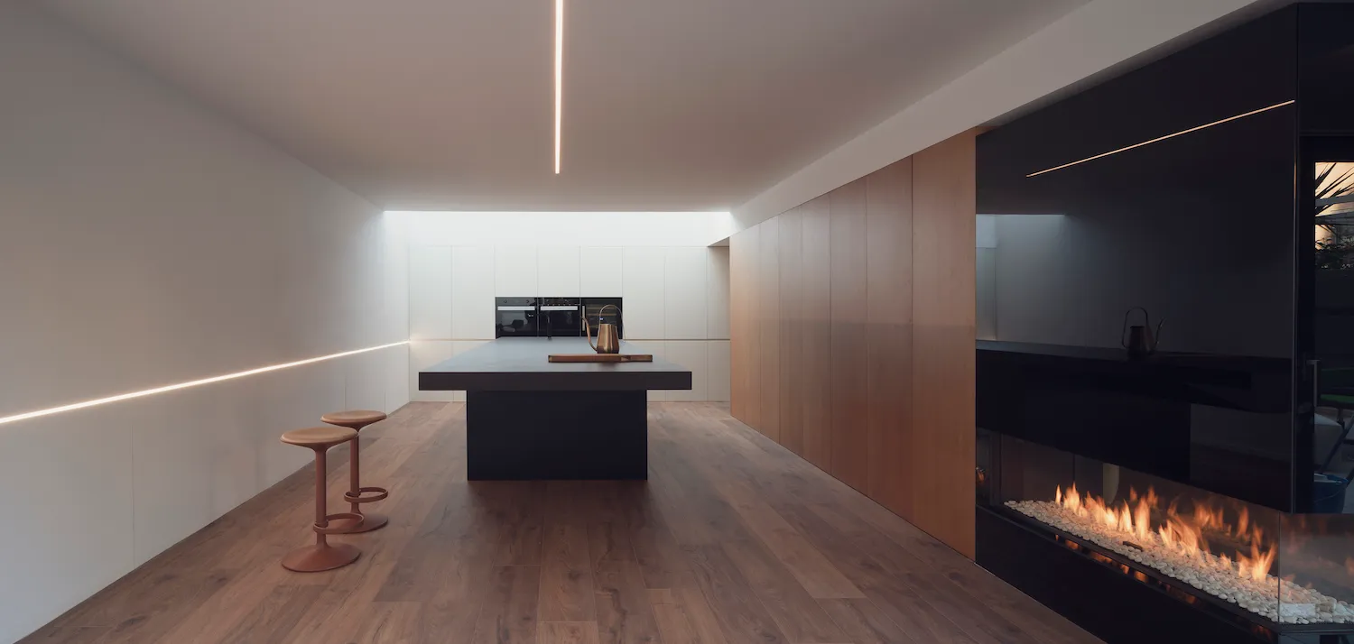 Modern kitchen with an empty space, featuring wooden flooring and minimalist design.