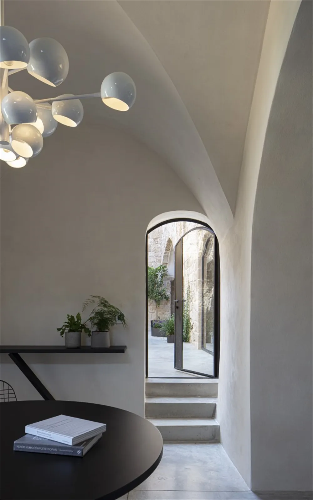 Angular concrete staircase leading to an industrial-style loft with modern furniture and exposed concrete walls.
