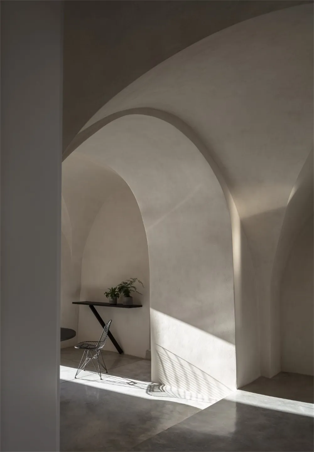 A modern industrial interior with curved concrete walls and minimalist design