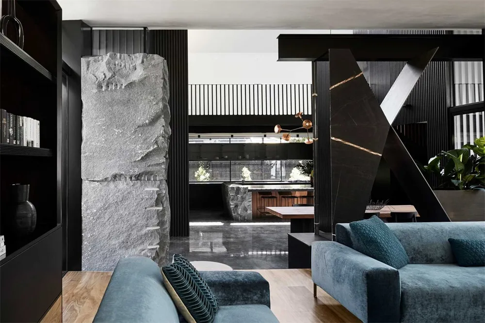 A modern living room featuring black marble and stone accents
