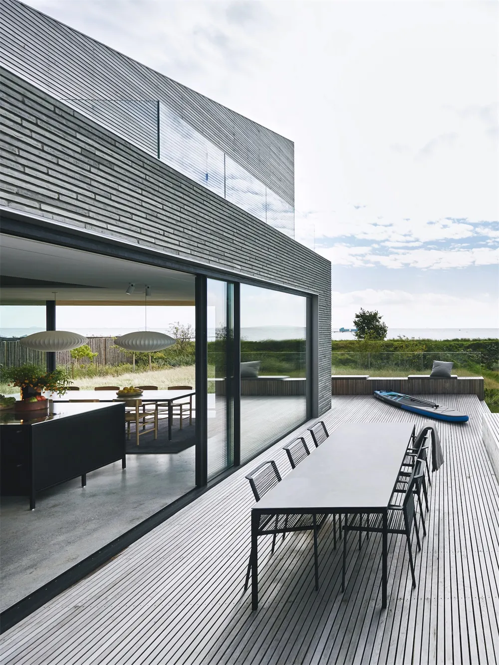 Modern residential architecture featuring wood and metal materials with a glass curtain wall.