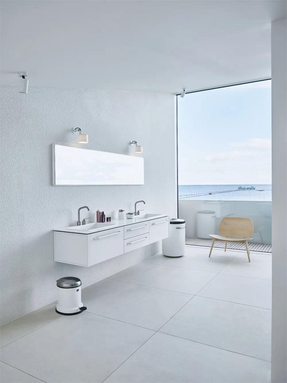 Modern minimalist white bathroom with a view of the ocean.