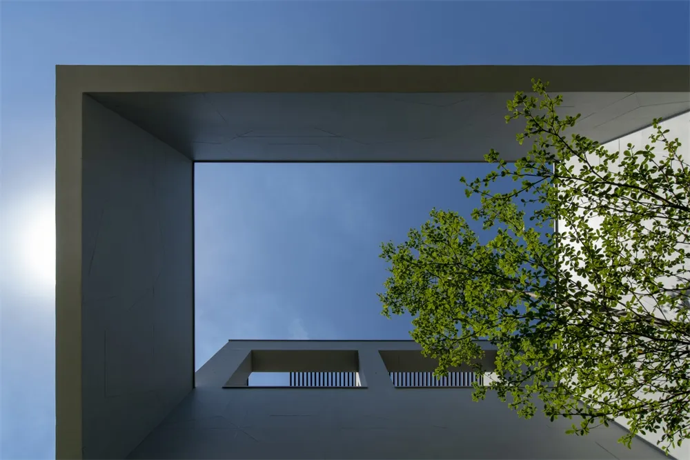 現代建築外觀，採用混凝土材質，搭配清澈藍天。