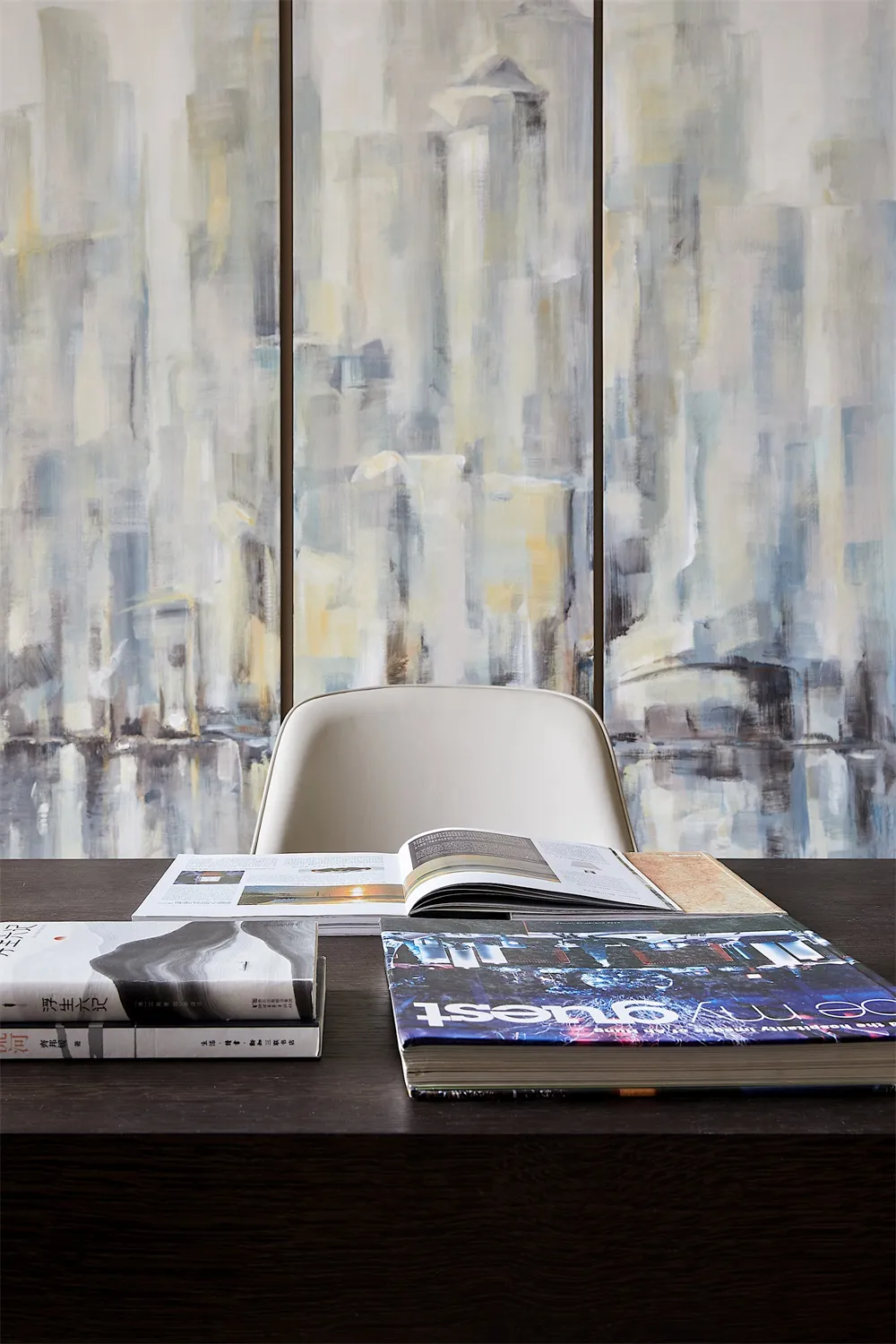 A modern glass bookshelf against a gray wall.