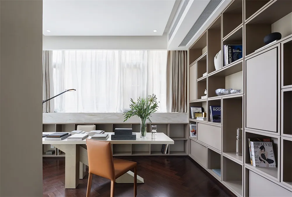 A modern, minimalist home office with a marble desk, wooden floor, and bookshelf.