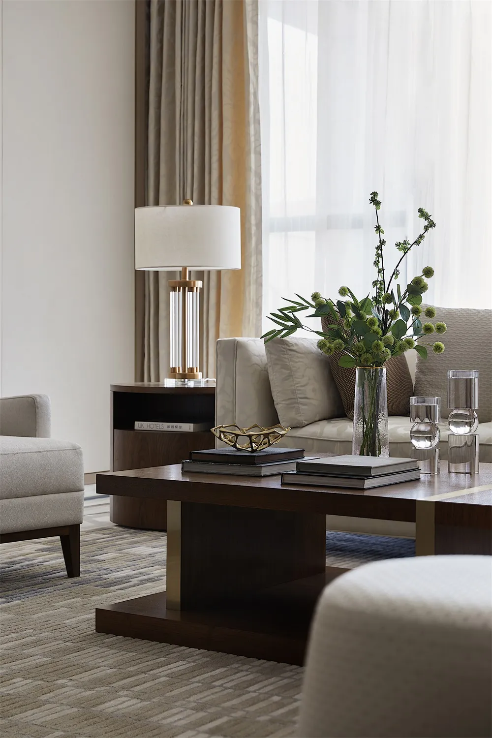 Modern living room featuring a wooden coffee table with books, a vase, and a lamp.