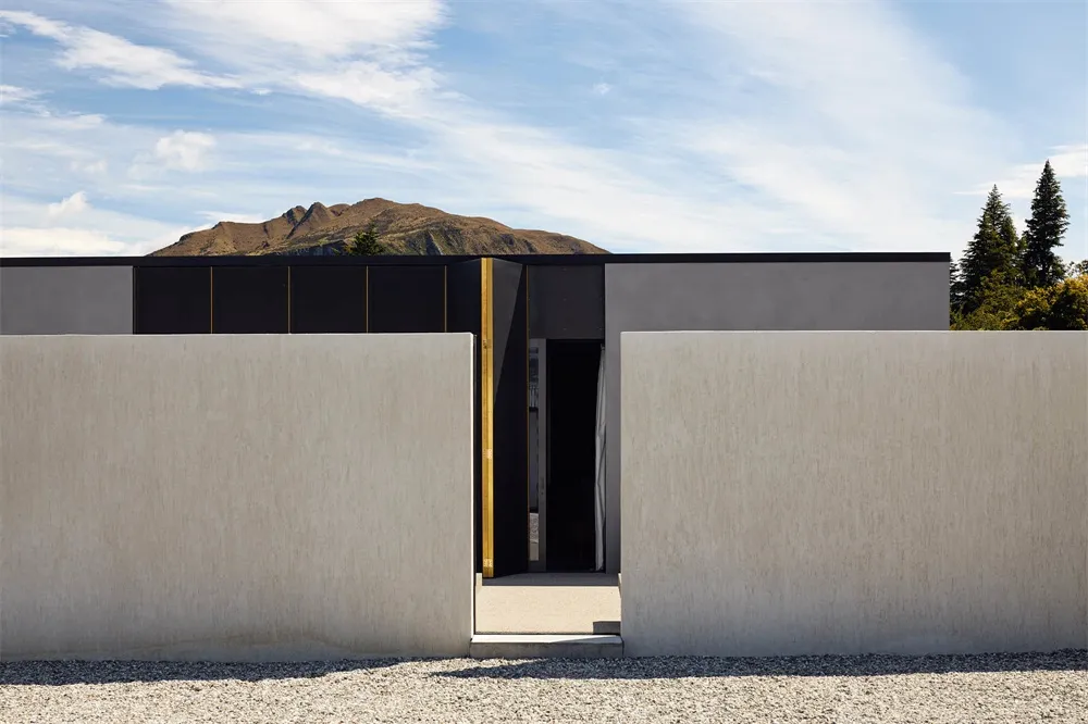 Modern minimalist house exterior with concrete facade and black window frames.