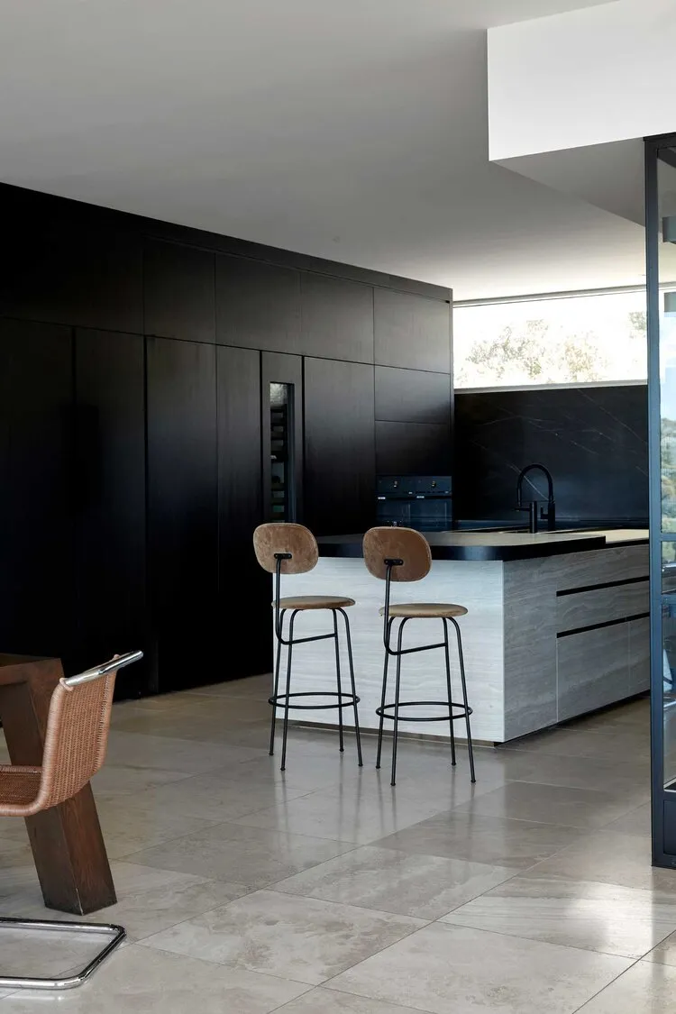 Modern minimalist kitchen featuring wooden cabinets and metallic elements.