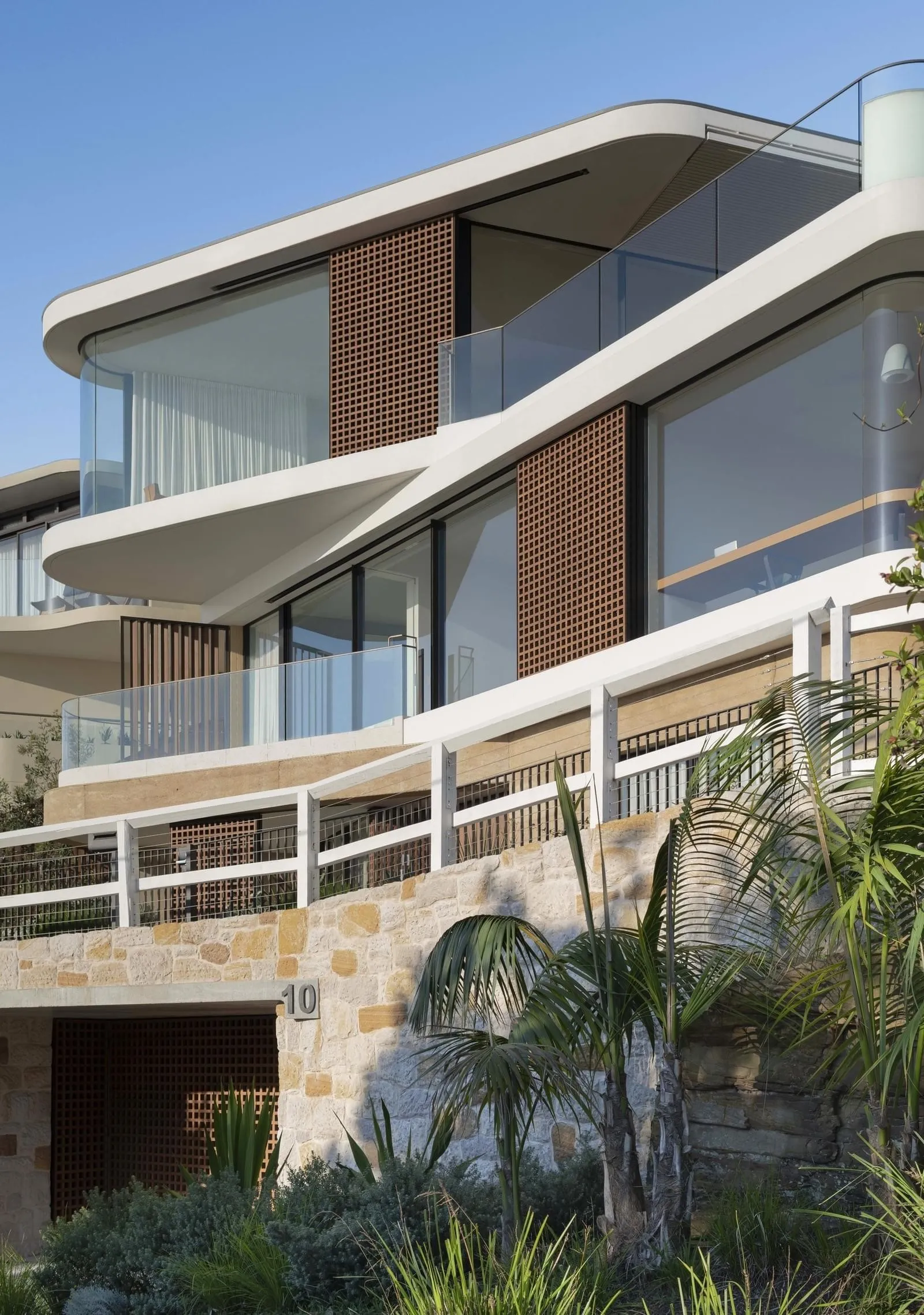 Modern residential house featuring glass, wood, stone, and metal exterior materials.