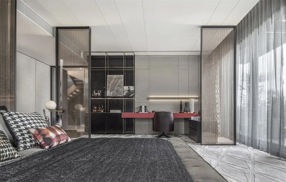 Modern industrial bedroom with a minimalist design, featuring a dark grey bed frame, clear glass dividers, and a sleek desk.
