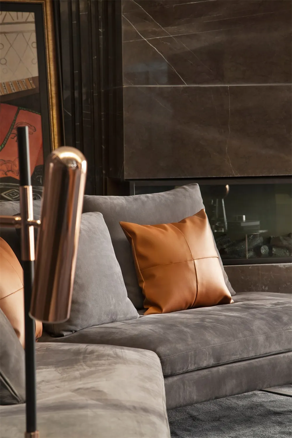 Modern living room featuring a leather couch against a marble wall