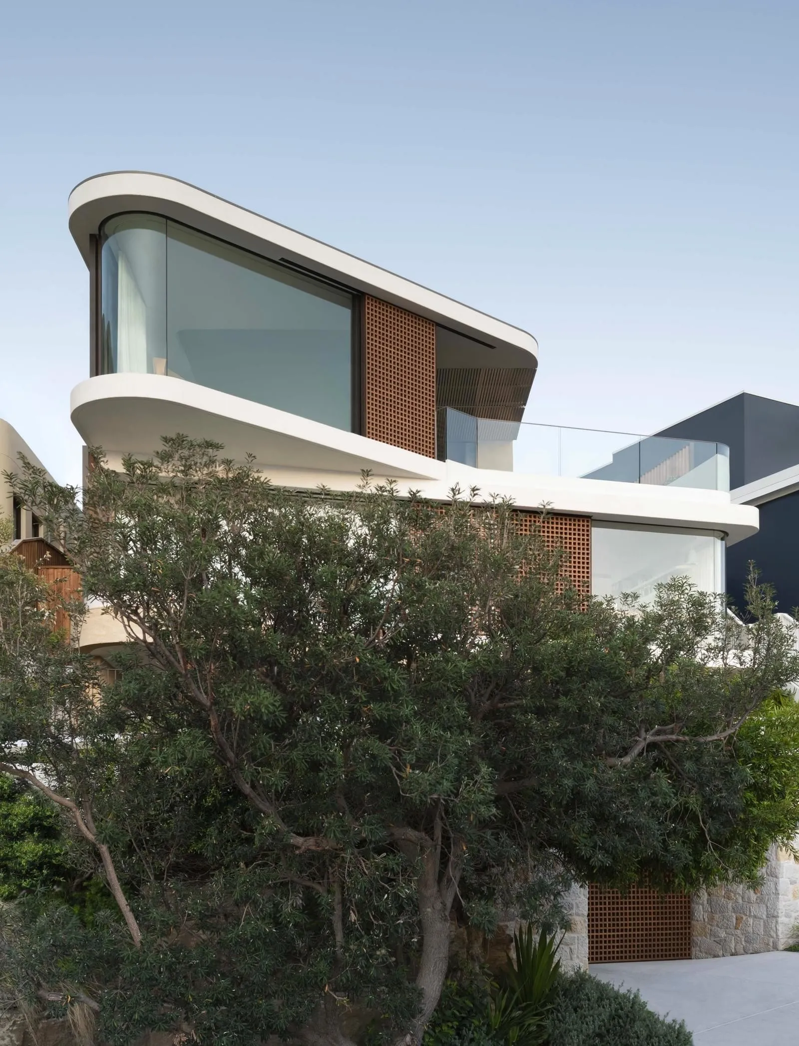 Modern residential building with mixed materials exterior and extensive use of windows.