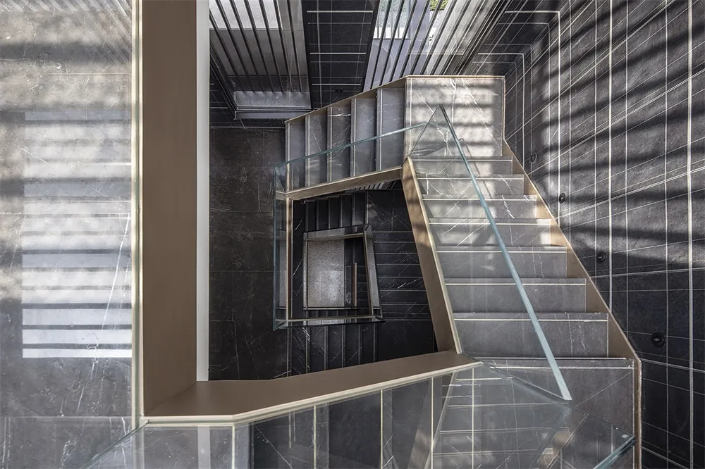 Modern staircase with concrete steps and glass railing
