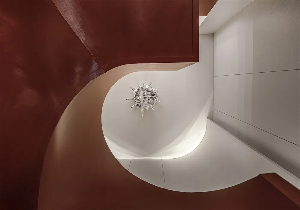 A modern staircase with metal railings and a spiral design.