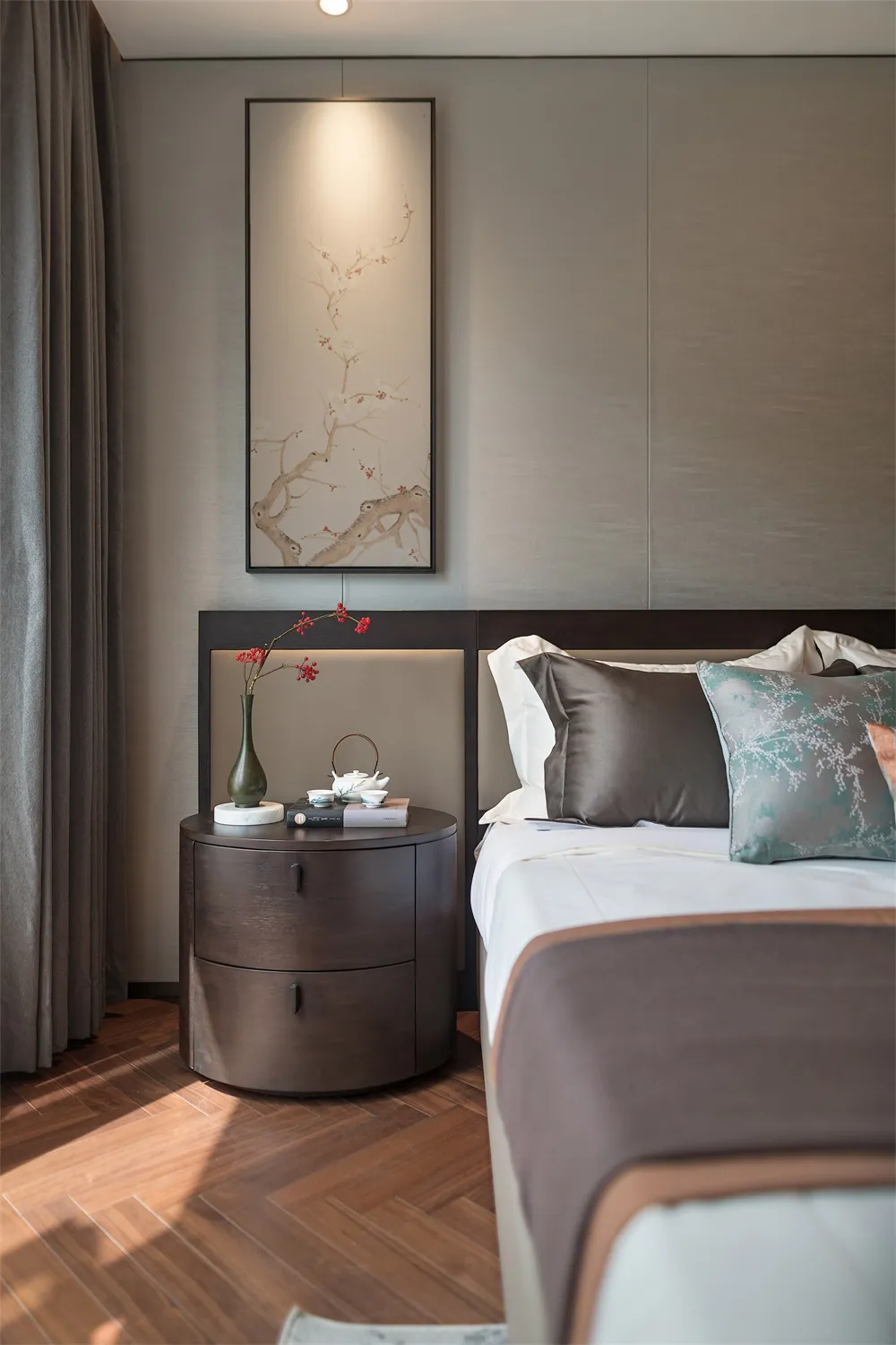 A modern bedroom featuring a bed with brown bedding, a wooden nightstand, and a floral painting above it.