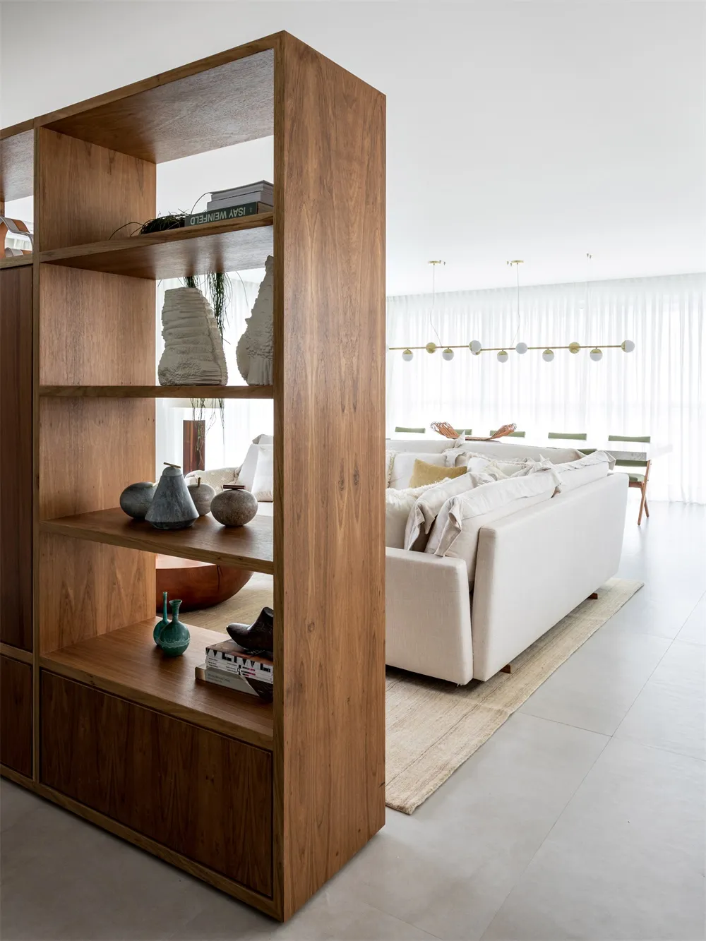 A modern living room featuring a wooden shelving unit with decorative items.