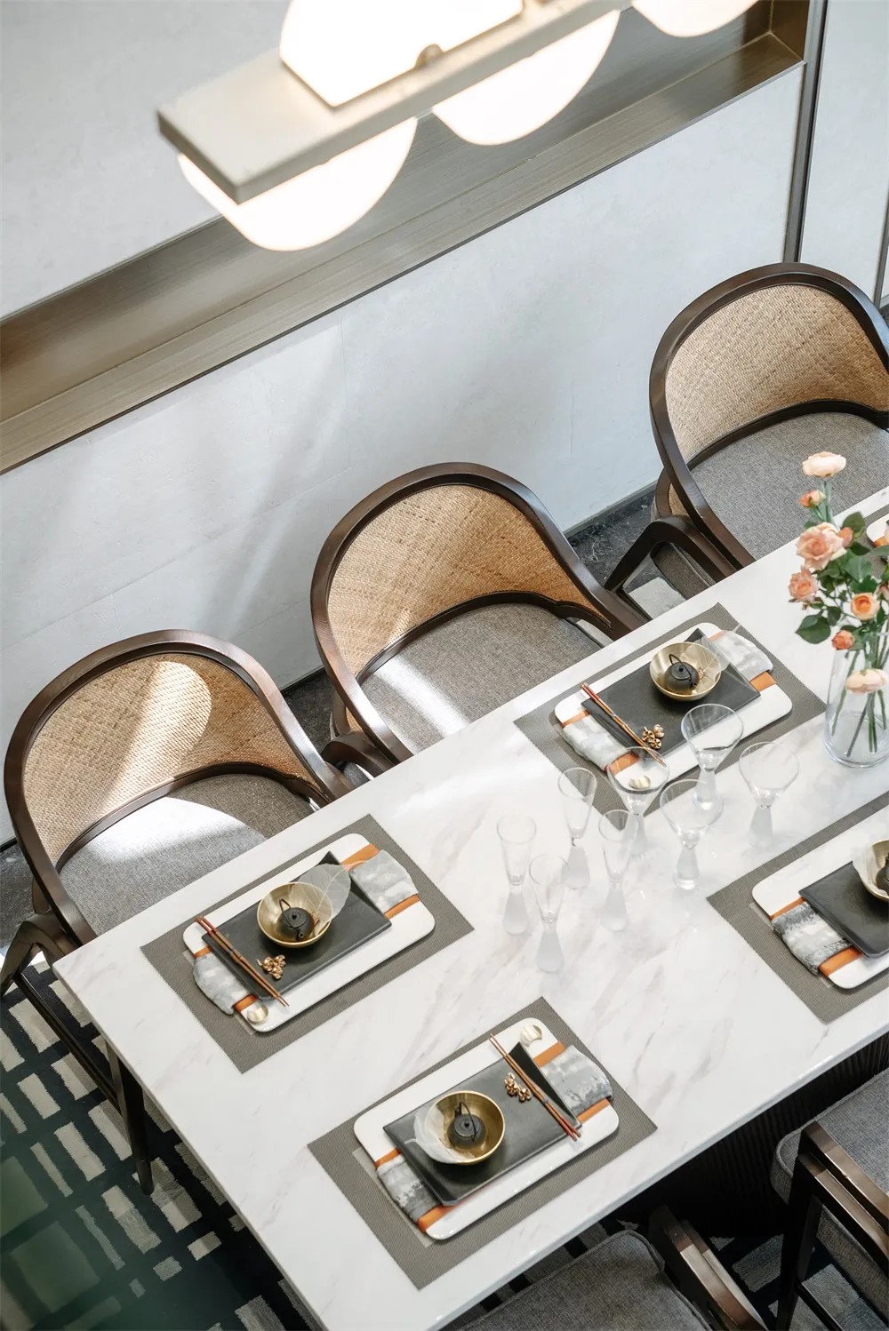 A modern dining room featuring a marble table with place settings.