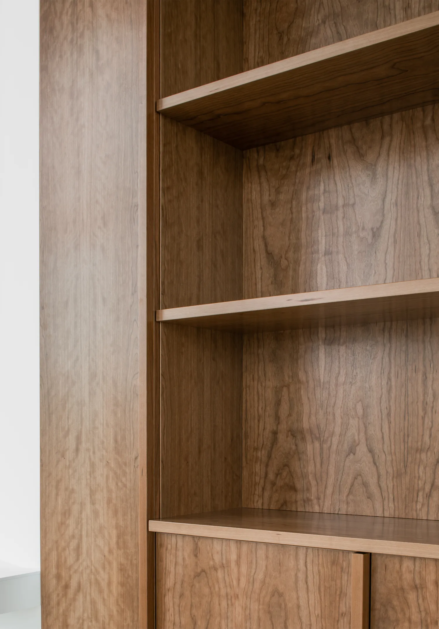 Modern bookshelf featuring wooden shelves and a sleek design.