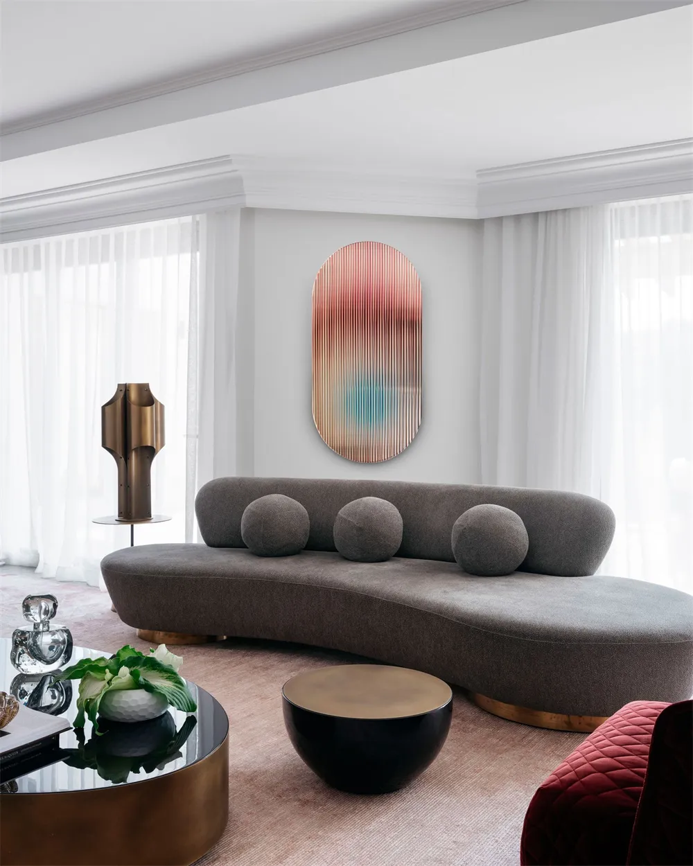 A modern living room with a曲面沙发, round brass tables, and a brass lamp.