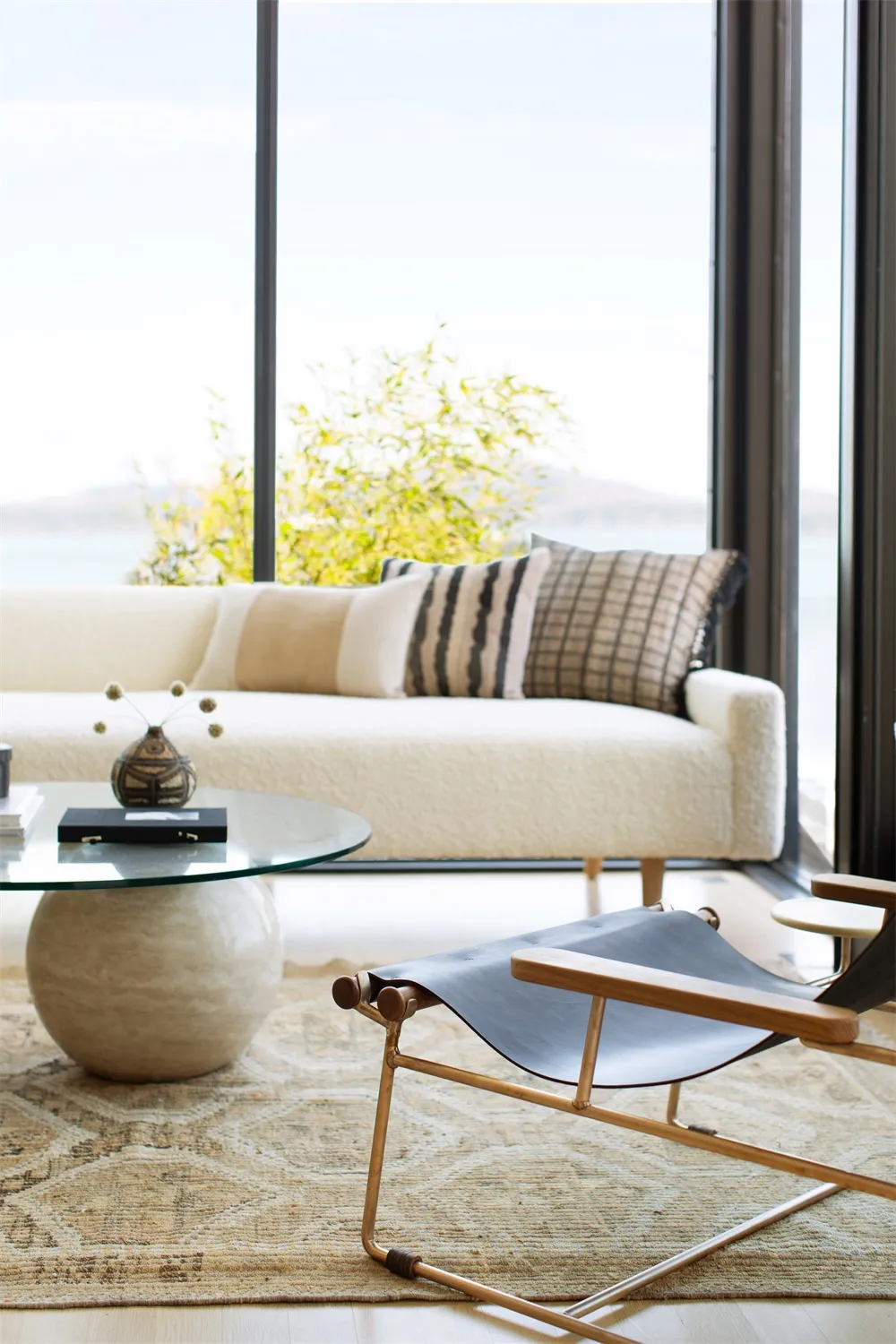 Modern living room featuring a white couch with soft, plush cushions, a glass coffee table, and a sleek, black lounge chair o