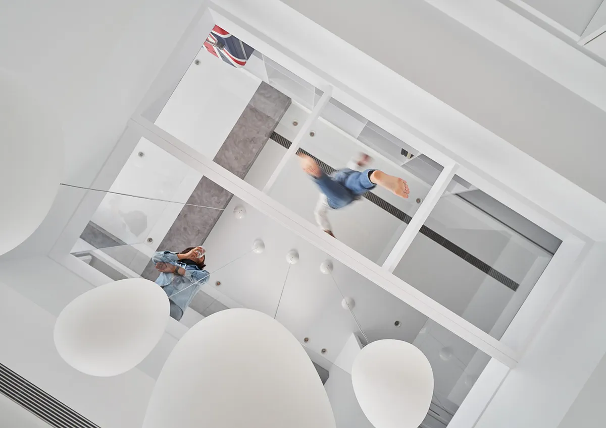 A modern office space featuring glass walls, metal accents, and concrete flooring.