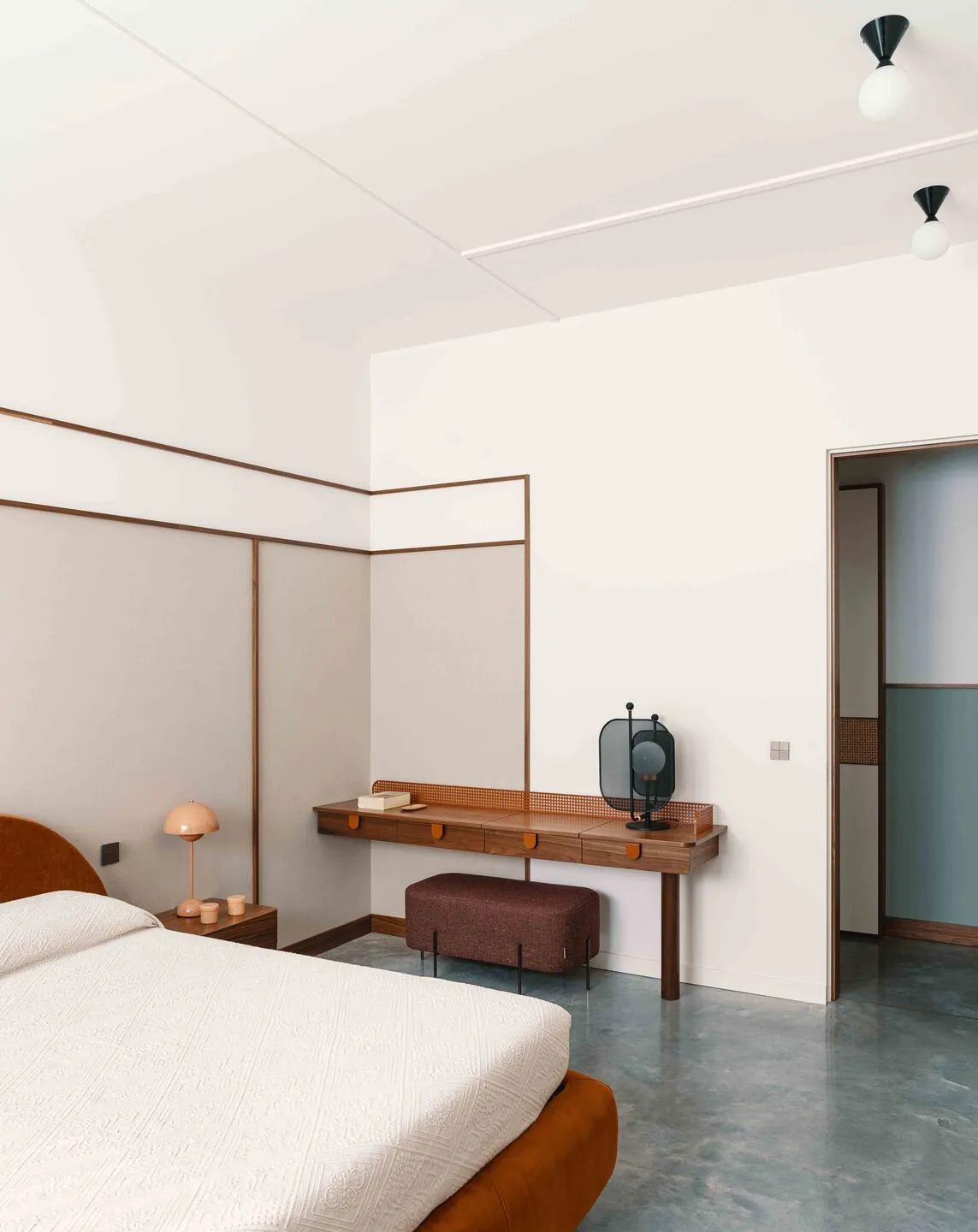 Minimalist bedroom with concrete flooring, wood furniture, and white walls and ceiling