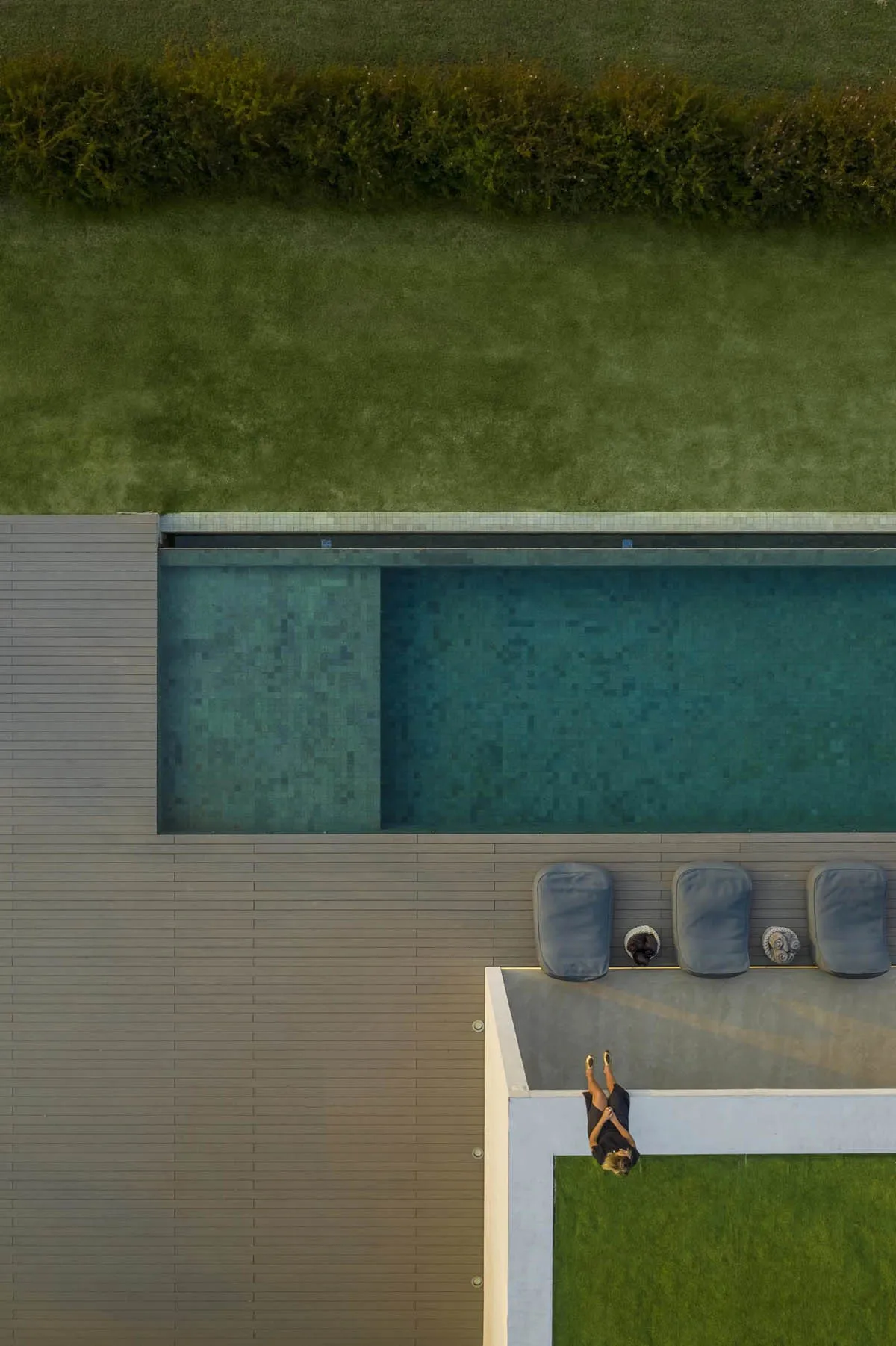 A modern swimming pool deck featuring wood and concrete materials.