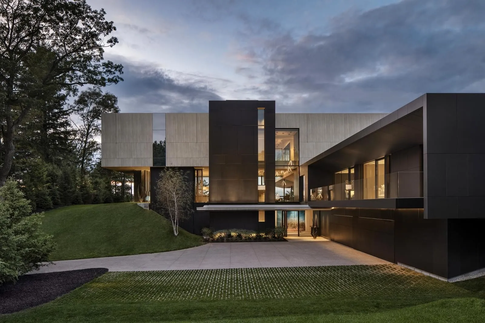 A modern house featuring a concrete exterior with large windows and a sleek design.
