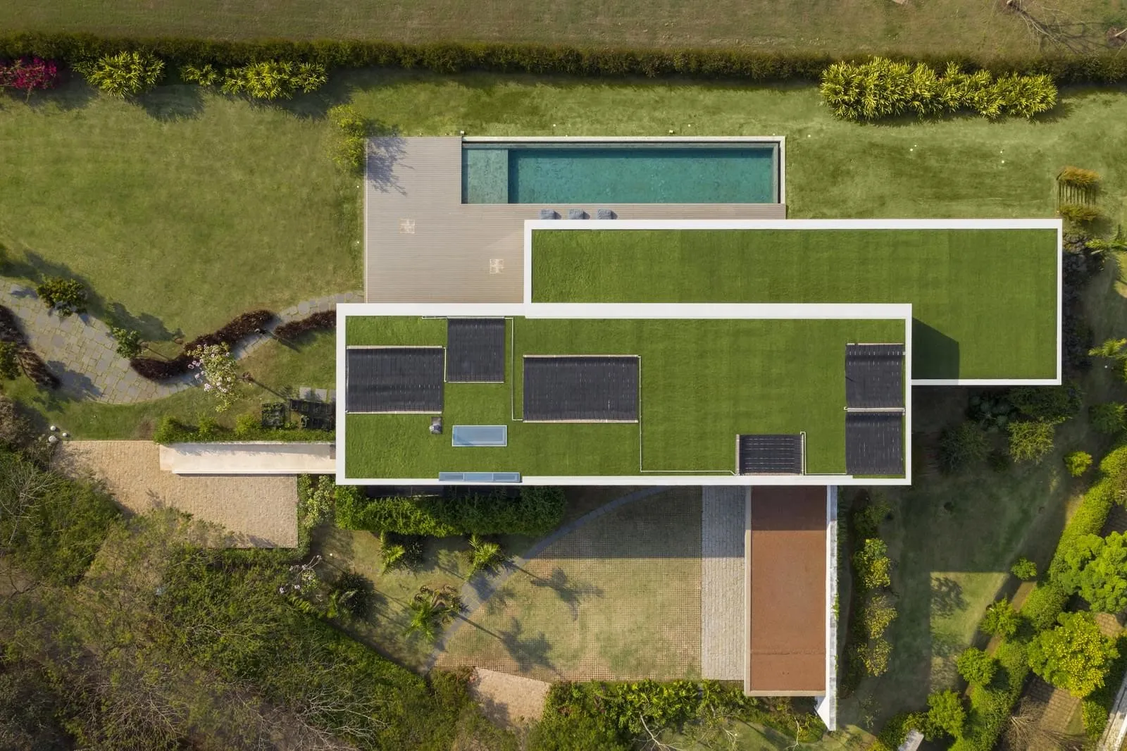 A modern residential home with a green roof, featuring a minimalist design and sleek architecture.