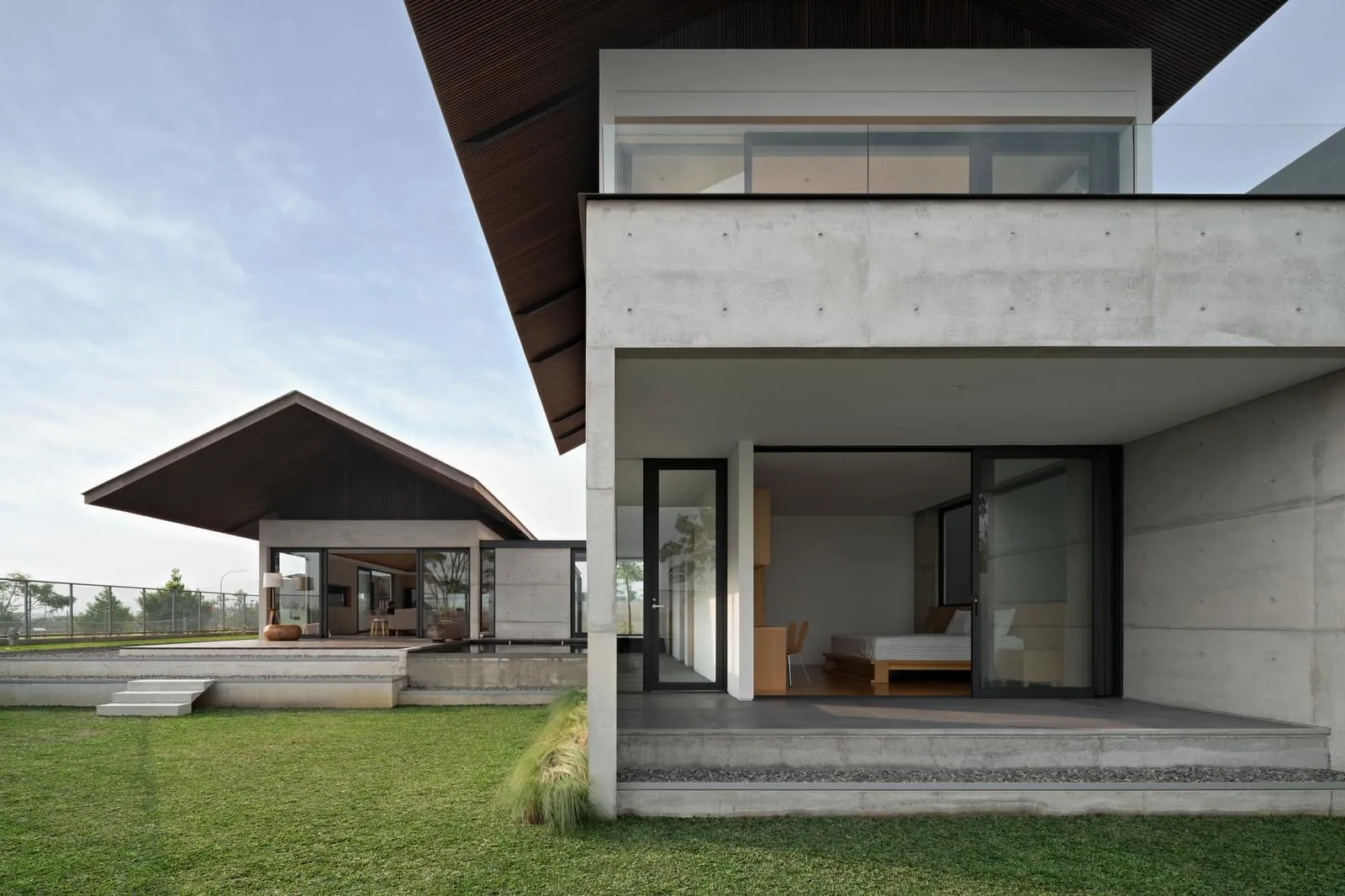 A modern residential exterior with a concrete exterior and large windows.