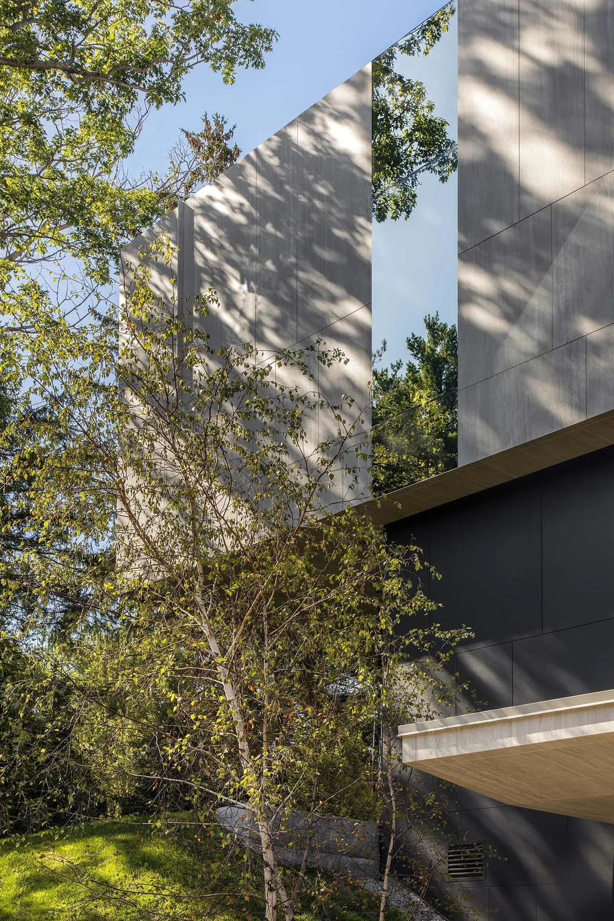 Modern residential building with concrete and glass exterior materials.