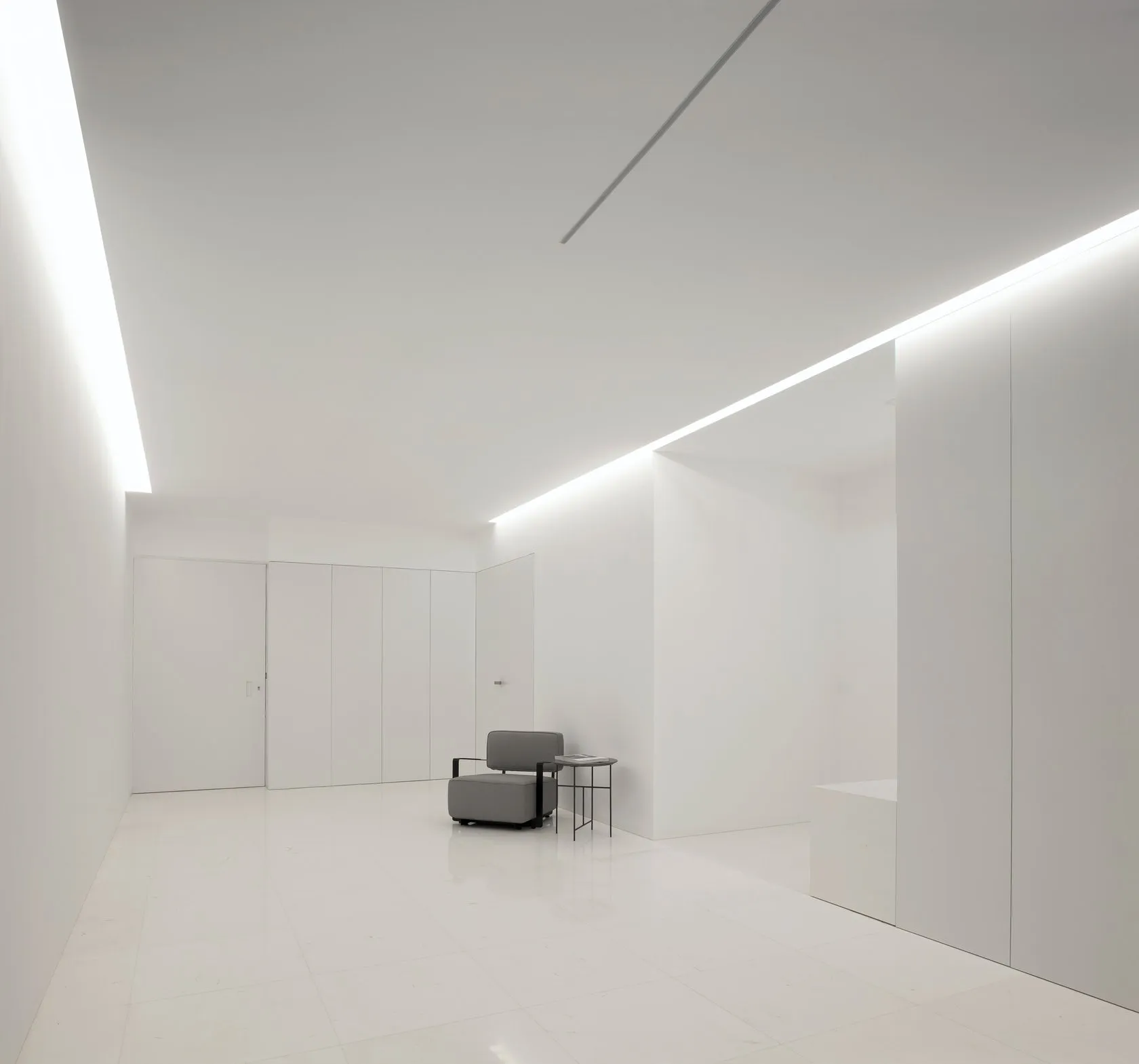 A minimalist office space with white walls and white floor tiles.