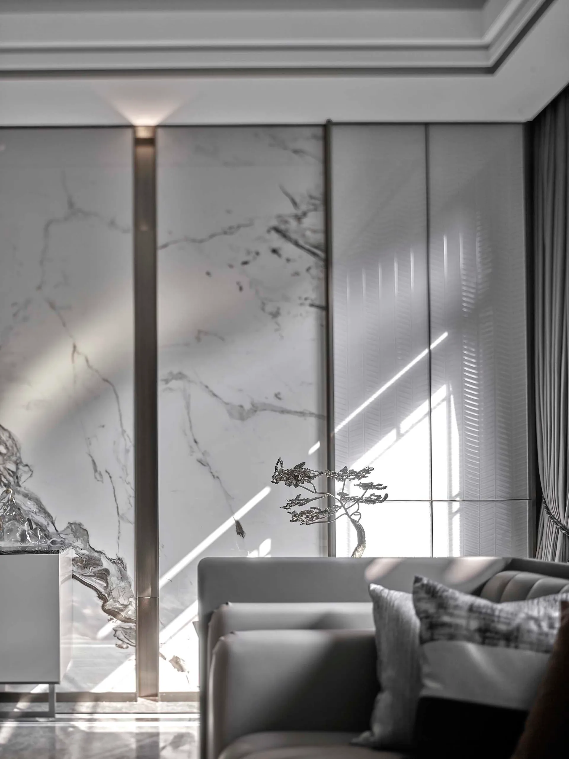 Modern interior design featuring marble patio and unique abstract metal decoration, with sunlight streaming through large sli