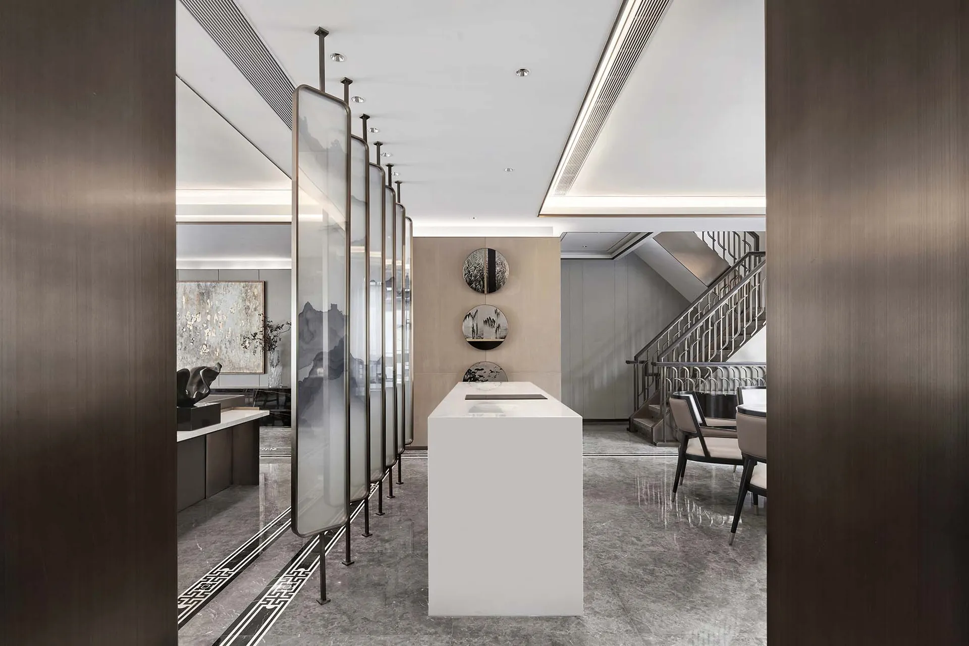 Modern office space featuring glass partitions and marble surfaces.