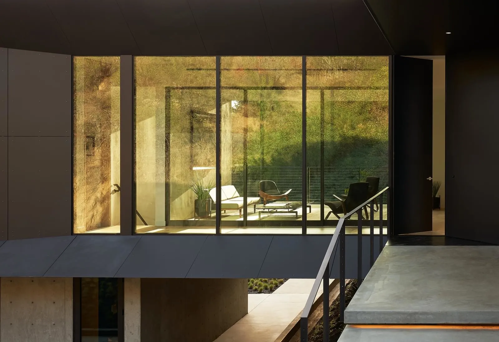 A minimalist living area featuring concrete and glass materials.