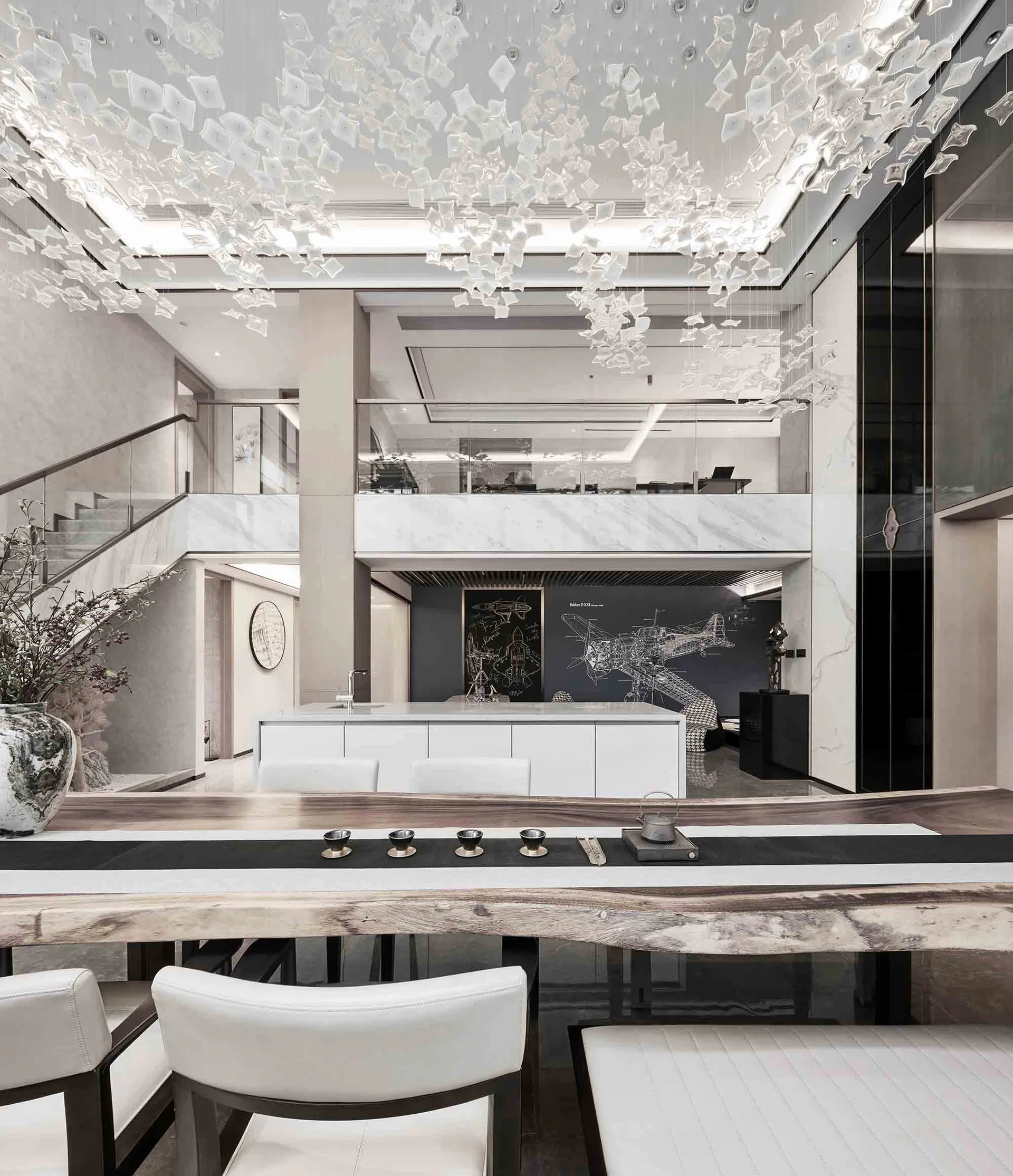 Modern dining room with marble table, white chairs, and glass chandelier