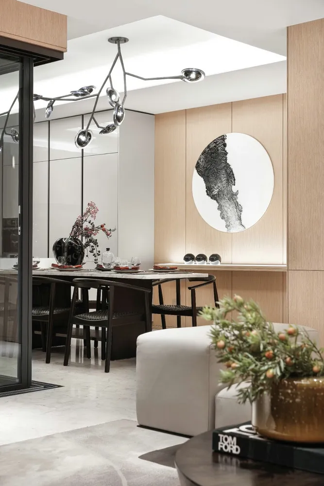 A modern dining room with wooden paneling, featuring a table set for dinner and a large abstract painting on the wall.