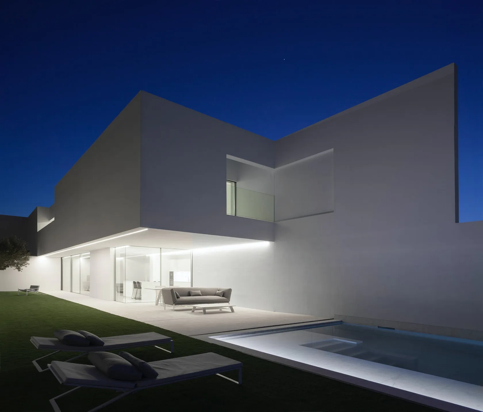 A modern exterior building with concrete walls and a glass door.