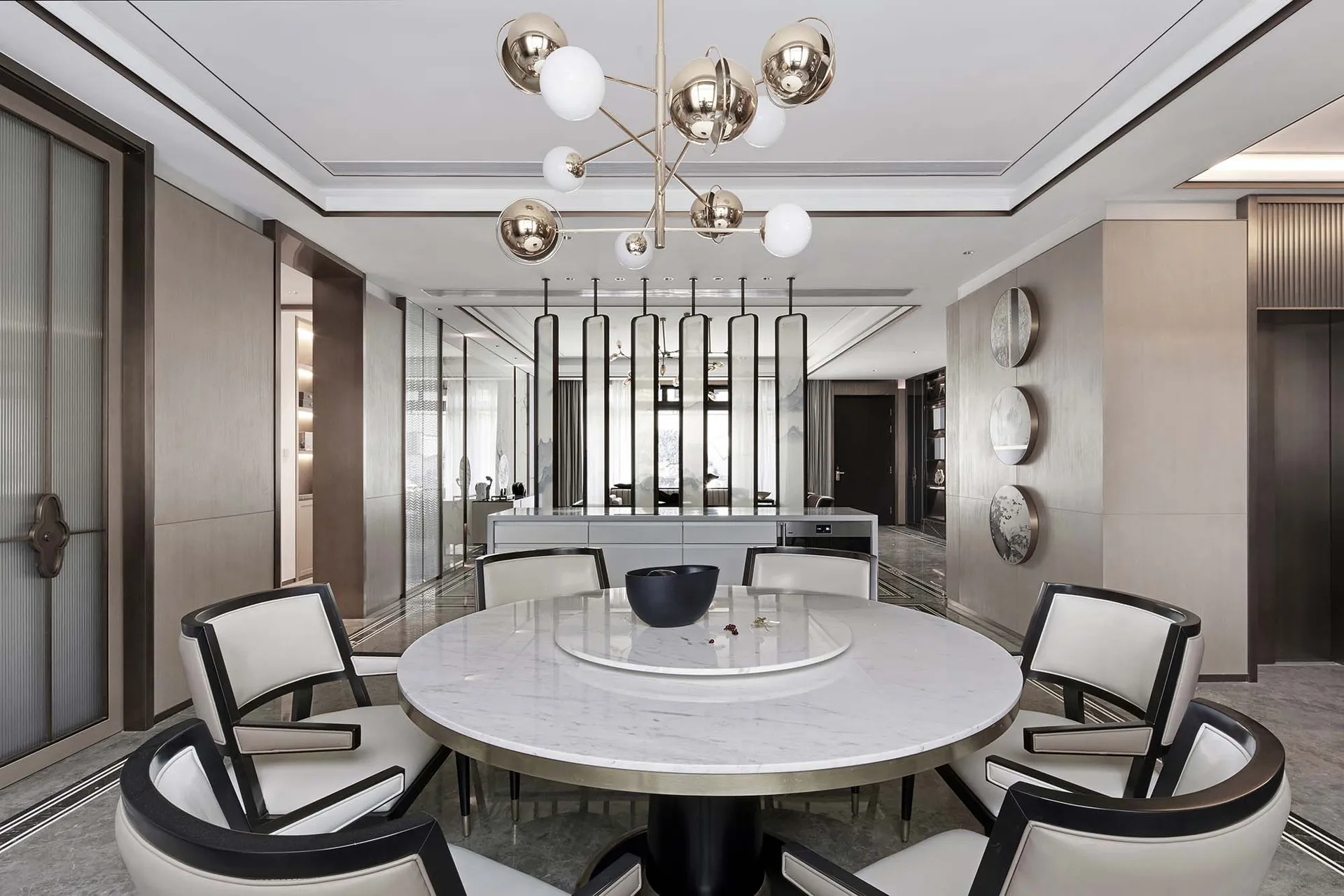 Modern living room with white marble accents, featuring sleek, black and white furniture and a contemporary light fixture.