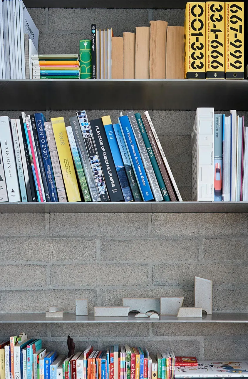 Modern concrete bookshelf displaying organized books.
